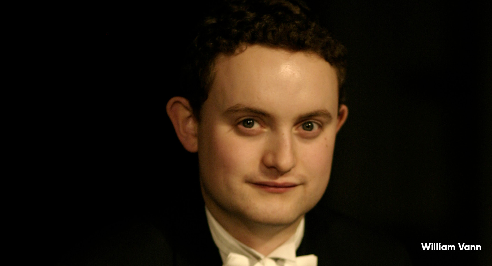 William Vann in black tie looking at camera