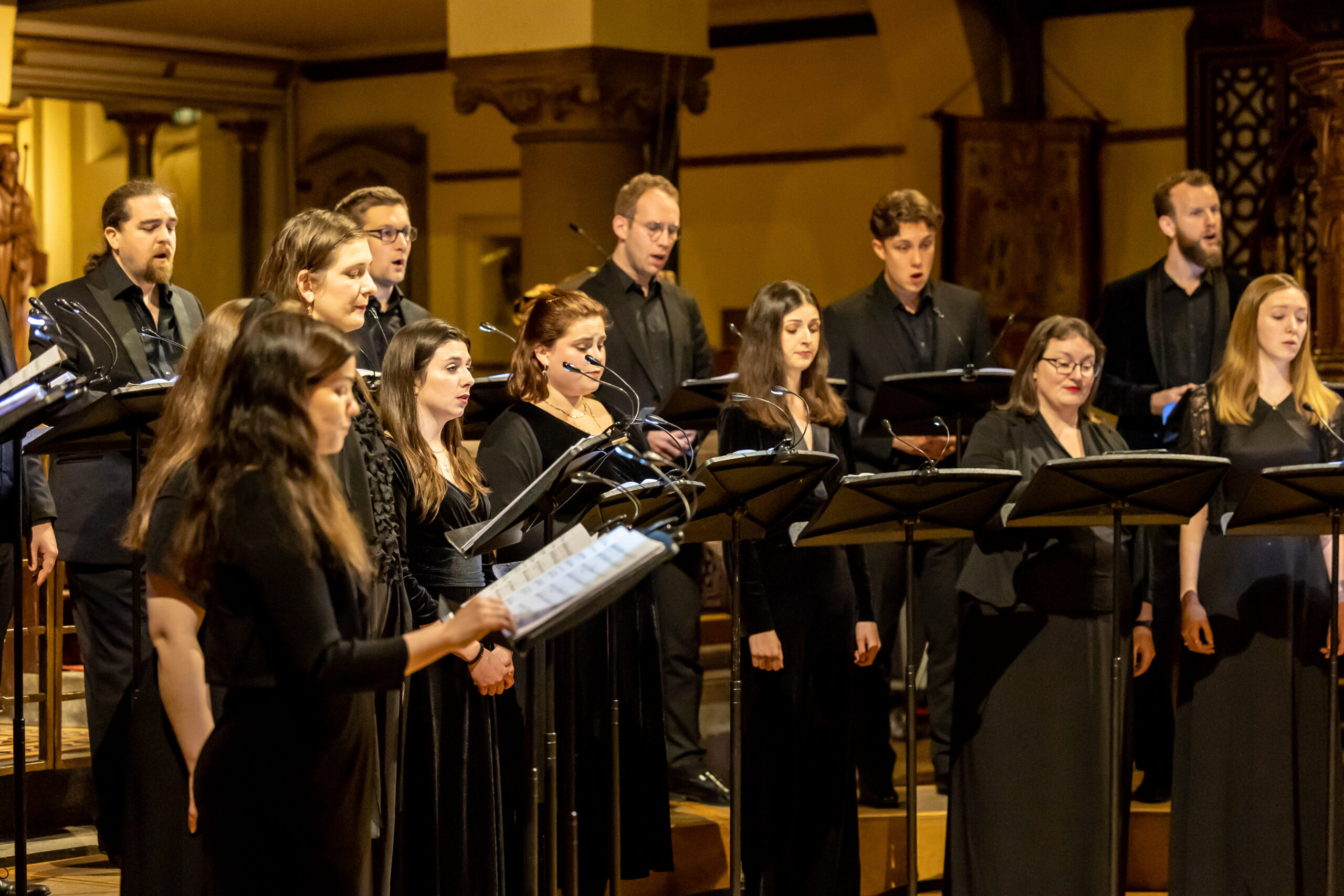 A close up of a choir with music on stands perform