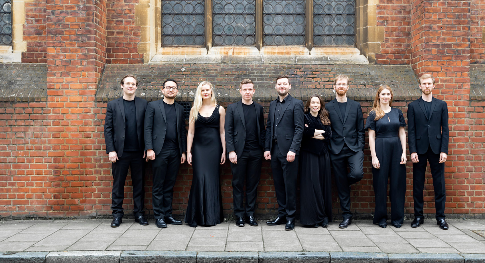 A picture of singers from The Marian Consort outside an old building