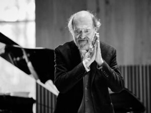 Arvo Pärt in black in white with his palms together