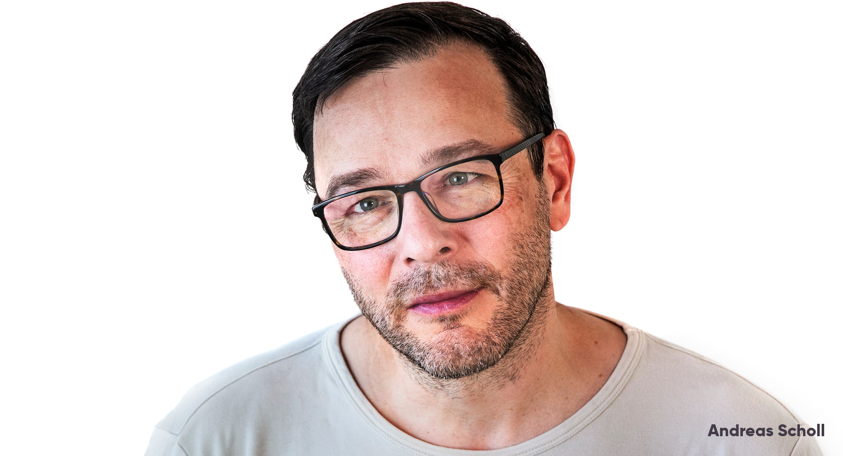 A press headshot of Andreas Scholl with a white background, wearing a light top, head slightly to one side.