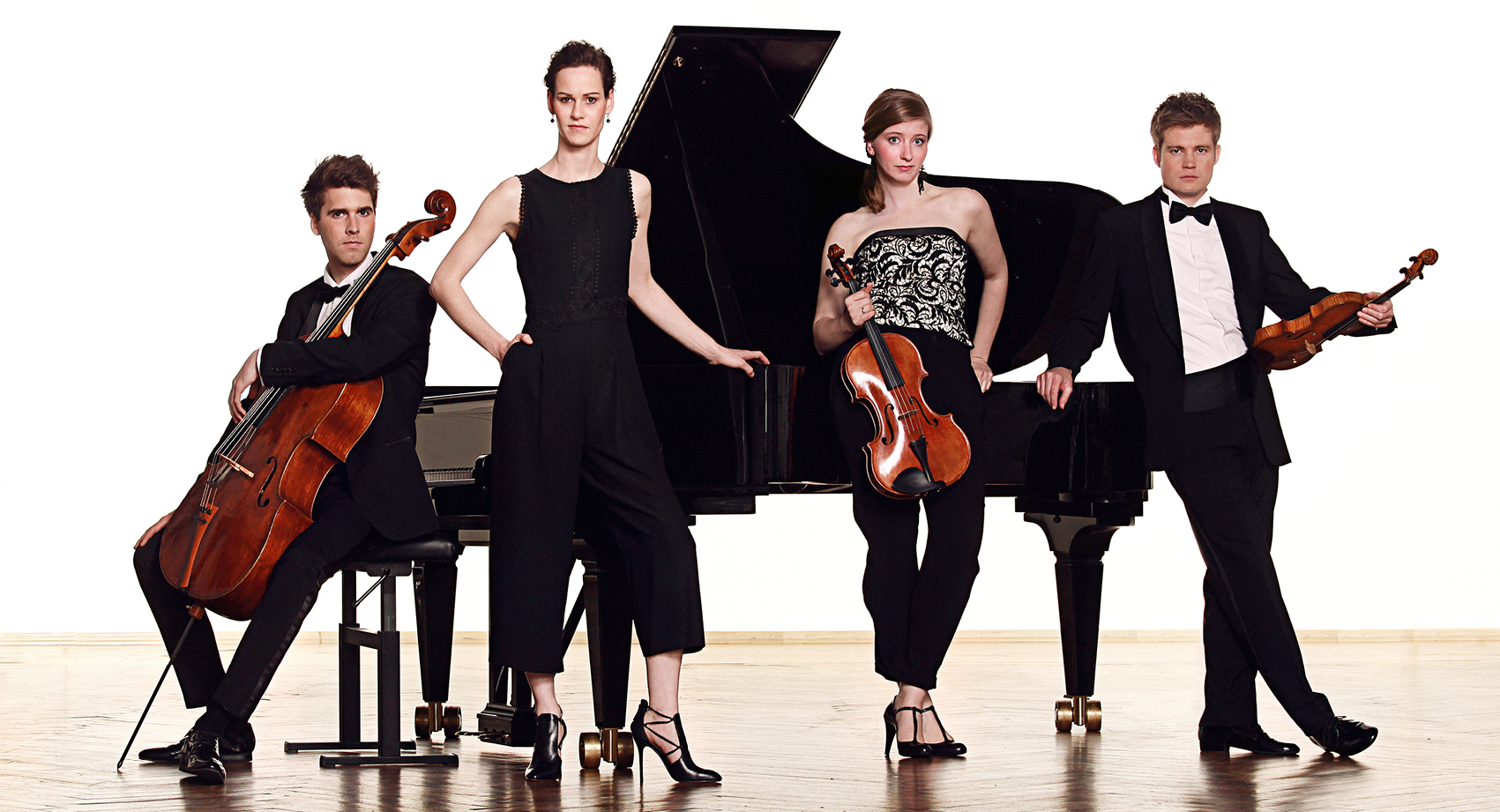 The Notos Quartet standing in front of a piano with instruments